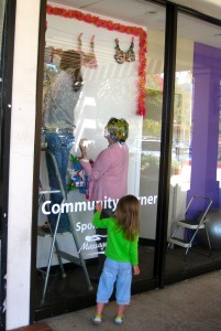 Three generations of women creating a Breast Cancer window display